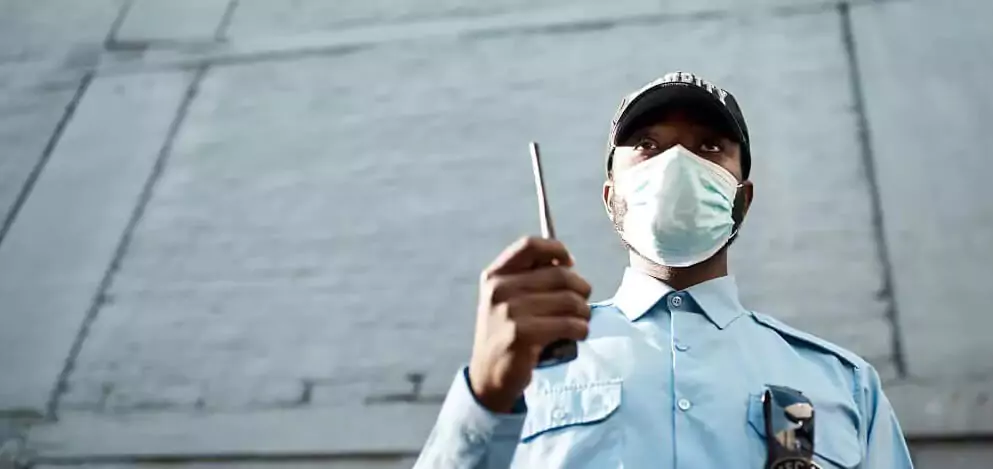 Segurança com comunicador do lado de fora de prédio