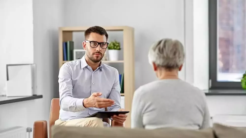 Psicólogo aconselhando mulher idosa em consultório