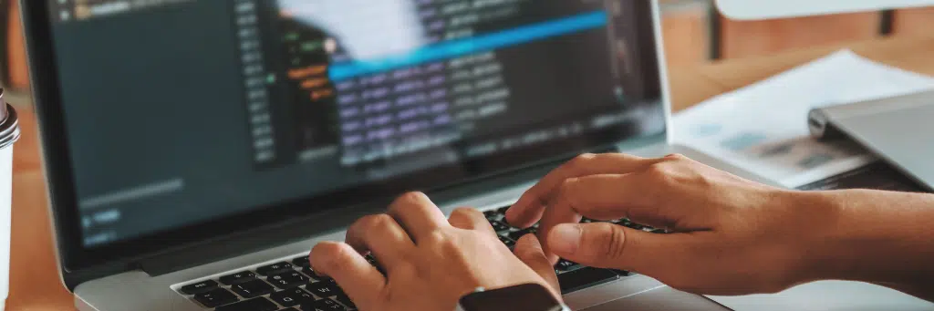 Homem digitando em laptop códigos