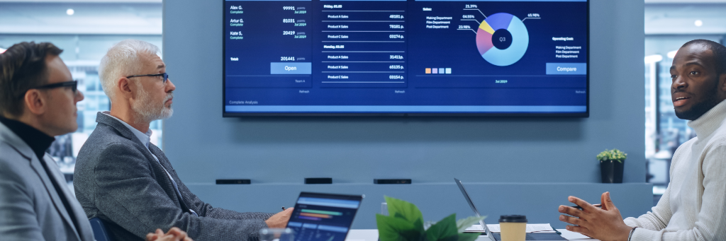 Reunião de negócios com painel com gráficos ao fundo