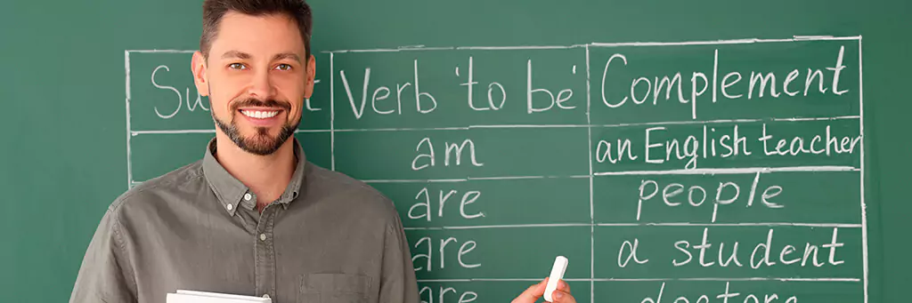 Professor de inglês em frente a quadro verde