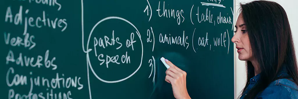 Professora de inglês escrevendo em quadro verde