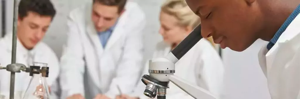 Garoto olhando em microscópio durante a aula