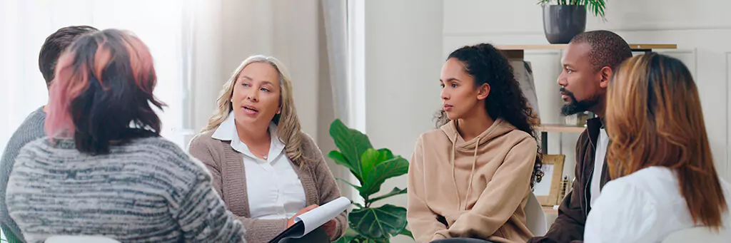 Psicóloga com grupo de pessoas em terapia