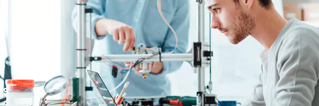 Rapaz digitando em computador em laboratório mecânico