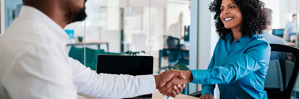 homem apertando a mão de mulher em escritório