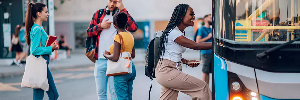 moça em faculdade subindo em ônibus