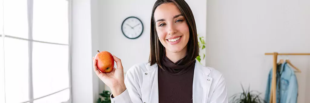 moça segurando maçã e sorrindo