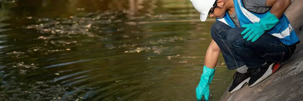 homem colhendo amostra em rio