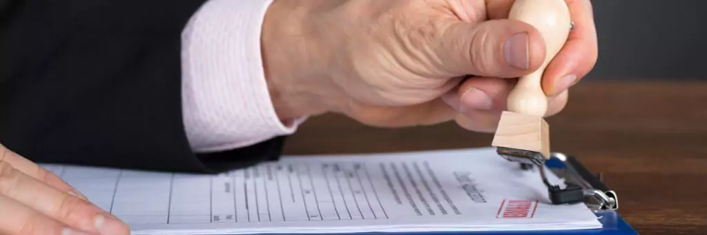 mão com carimbo aplicando em documento