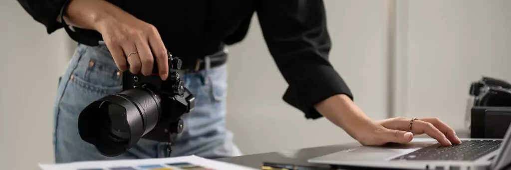 moça com câmera fotográfica mexendo em computador