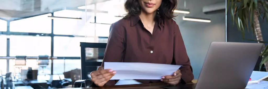 mulher analisando documento em escritório