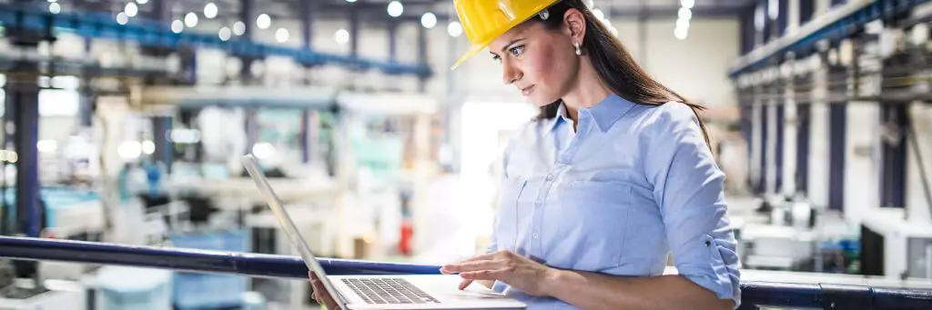 mulher mexendo em computador em fábrica
