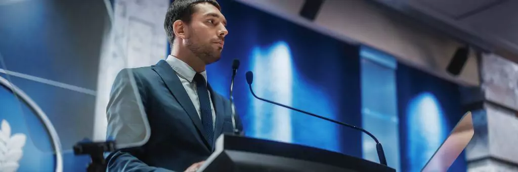 rapaz discursando em palco