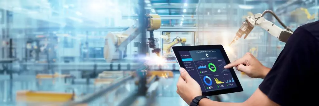 homem apertando botão em tablet para controlar braços mecânicos