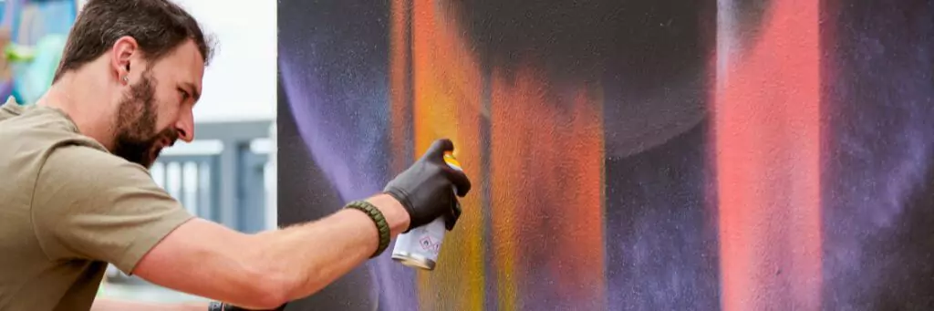 homem pintando quadro com spray